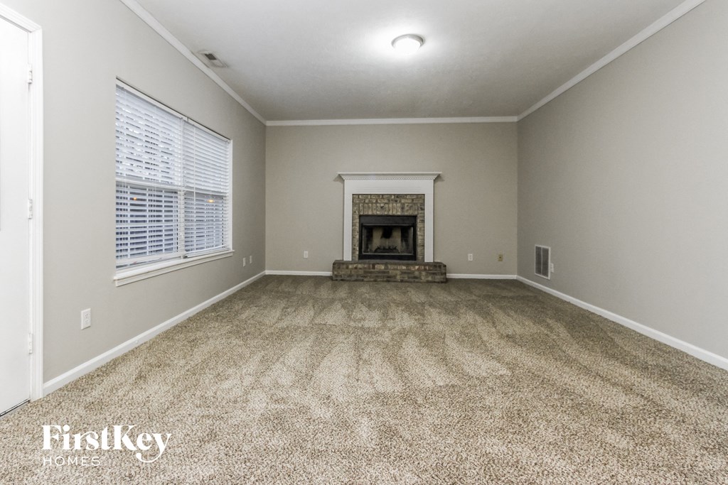 the living room of an empty house with a fireplace