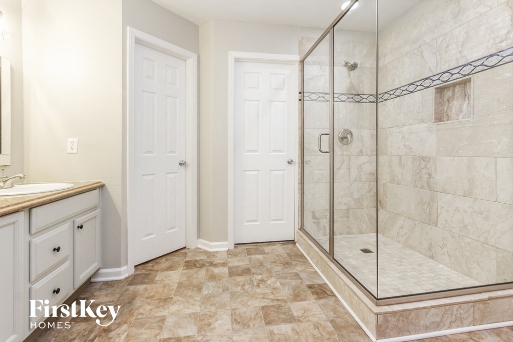 a bathroom with a shower and a sink and a mirror