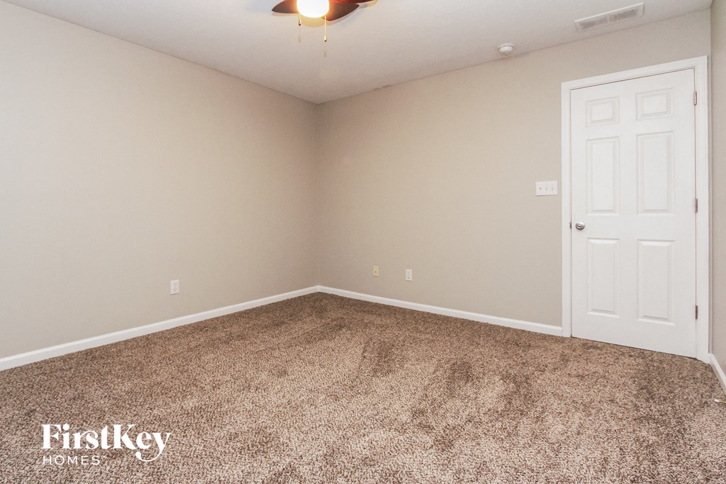 a bedroom with a carpeted floor and a white door