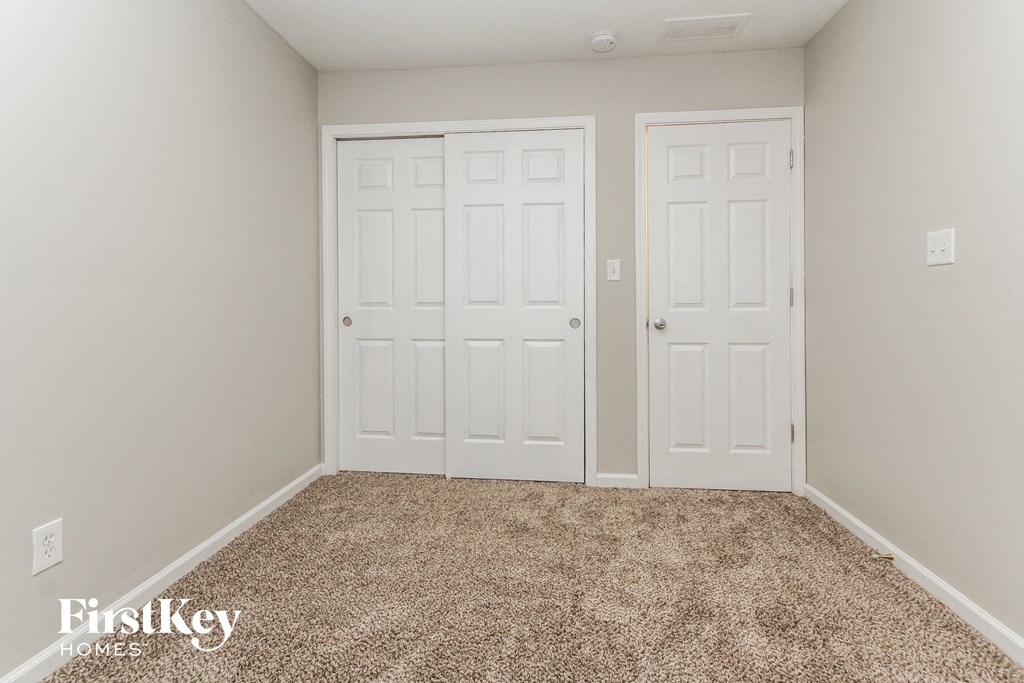 a bedroom with two closets and a carpeted floor
