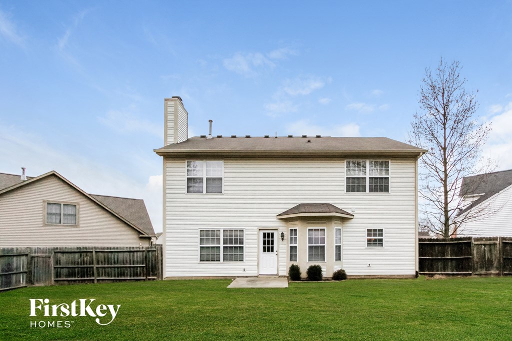 a white house with a yard and a wooden fence