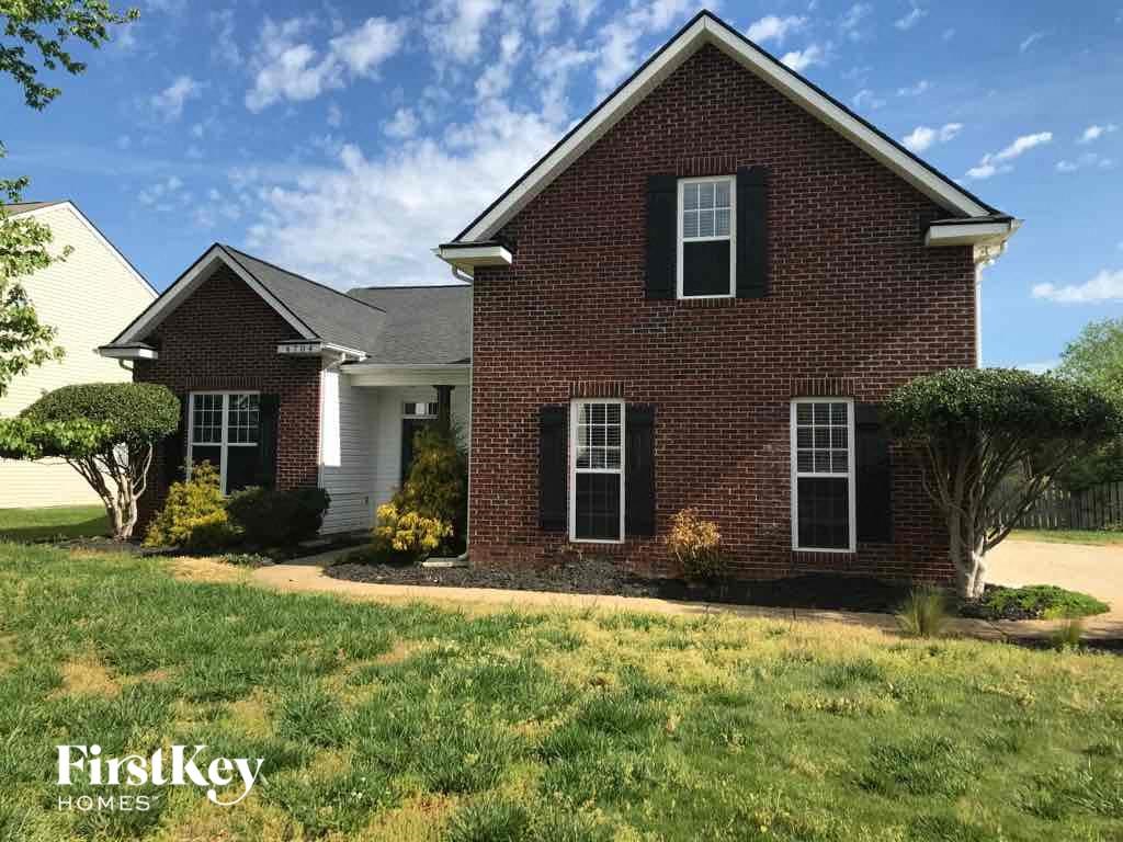 a brick house with a lawn in front of it