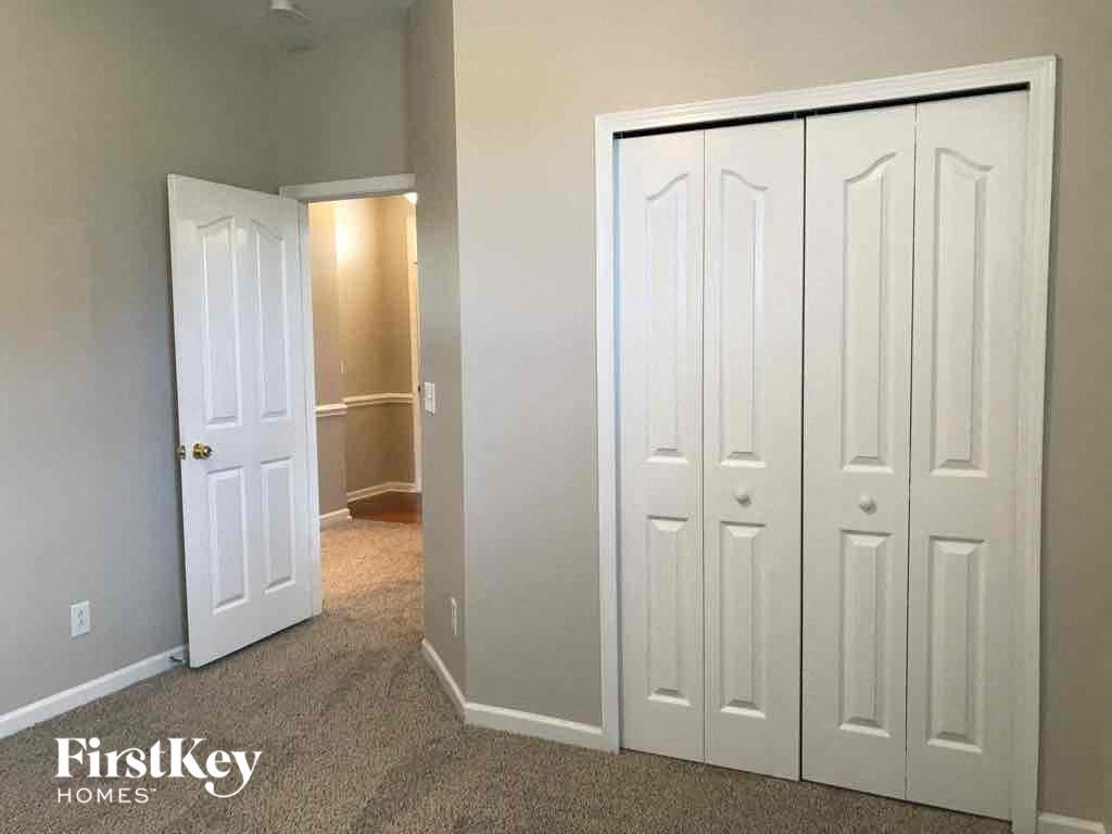 a bedroom with three closets and a door to a hallway