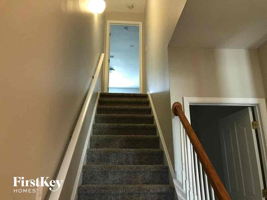 a stairway with a staircase railing and a door at the bottom of the stairs