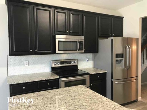 a kitchen with black cabinets and stainless steel appliances