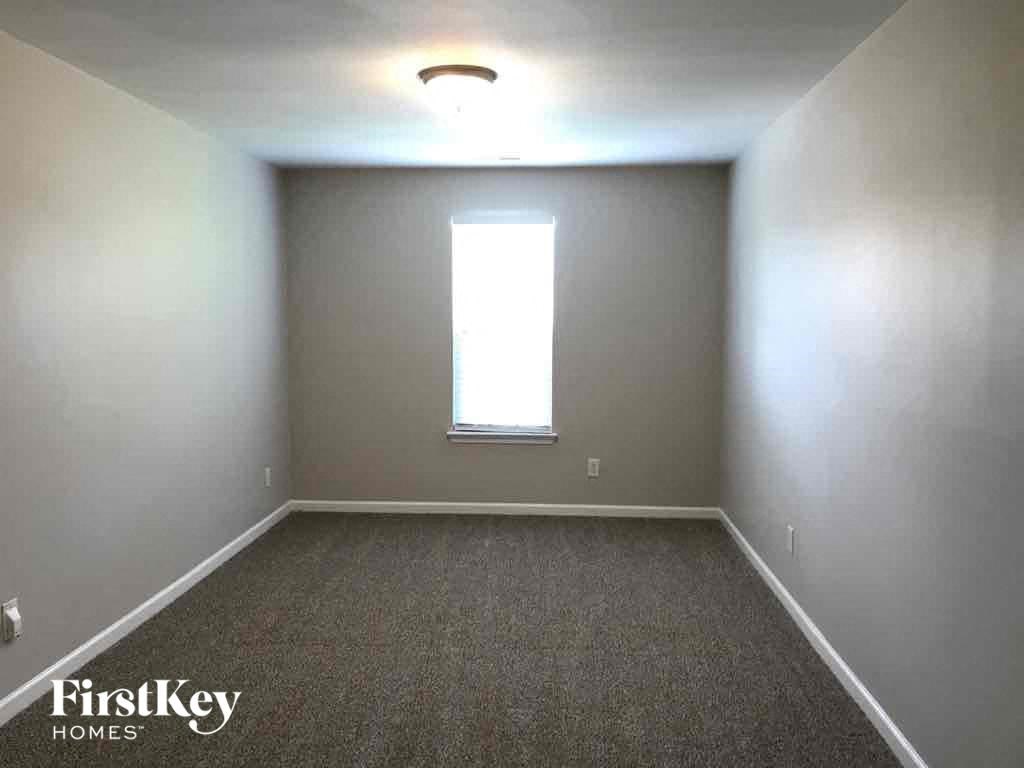 a empty room with a window and a carpet