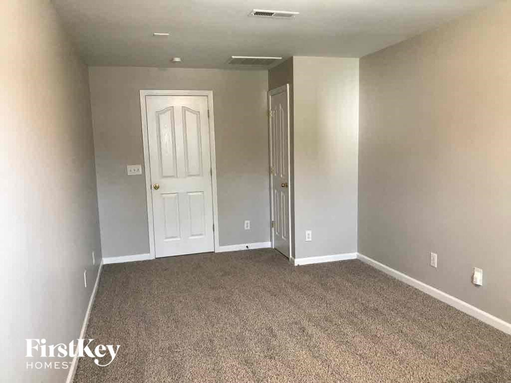 an empty living room with carpet and a white door