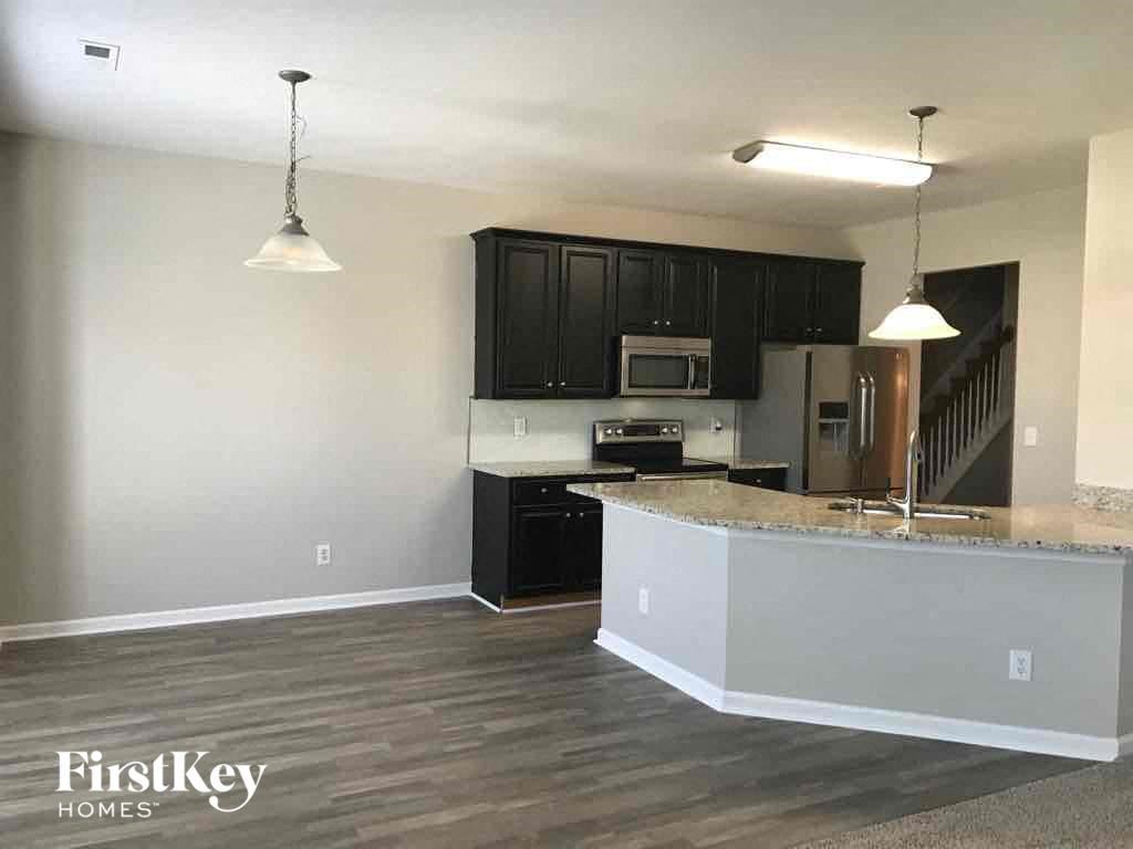 an empty kitchen with black cabinets and a counter top