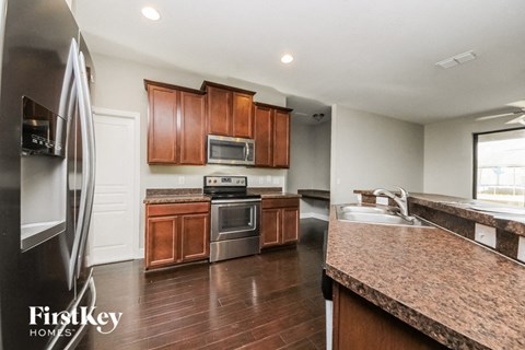 A kitchen with wooden cabinets and a granite countertop.