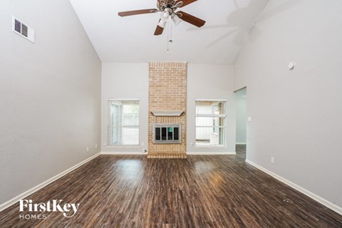 A room with a fireplace and a ceiling fan.