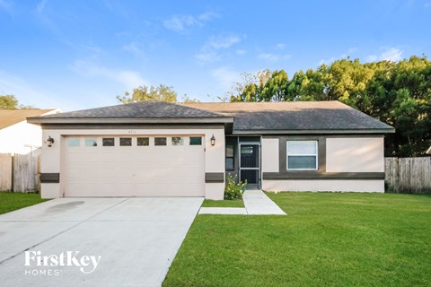 a white house with a lawn and a garage door