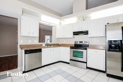 a kitchen with white cabinets and stainless steel appliances
