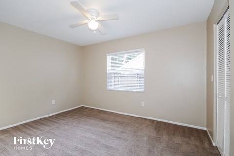 a bedroom with a carpeted floor and a ceiling fan