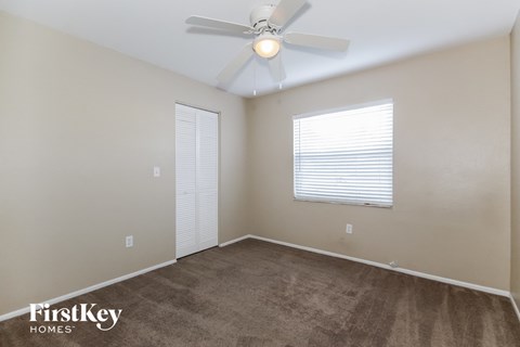 a bedroom with a ceiling fan and a carpeted floor