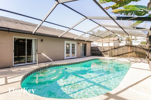 the pool is under an open patio roof with a pool