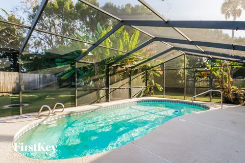 a swimming pool inside of a glassed in pool house