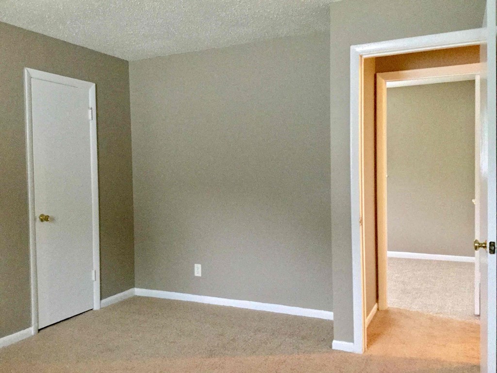 A room with two doors and a carpeted floor.