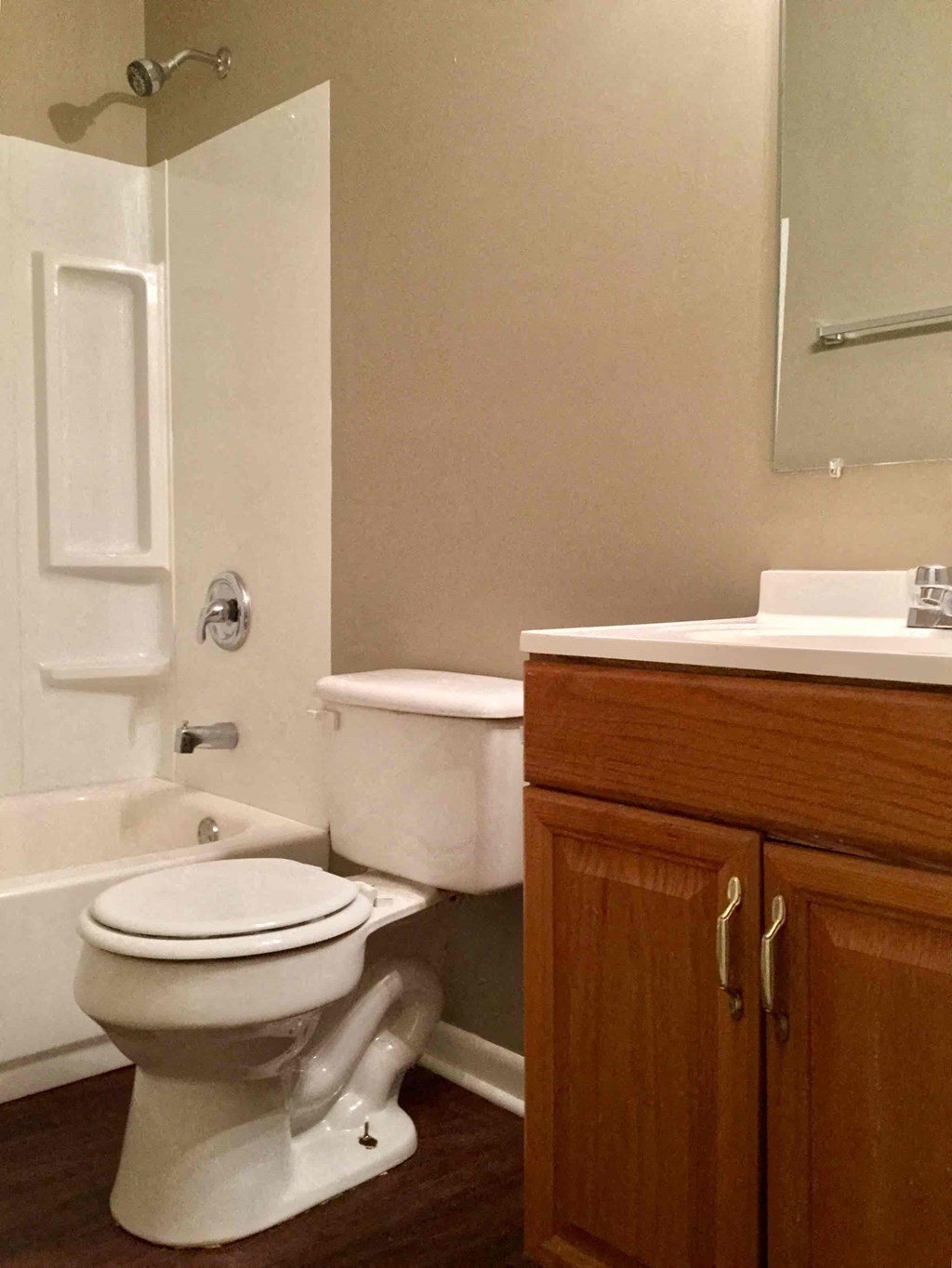 A white toilet sits in a bathroom next to a wooden cabinet.