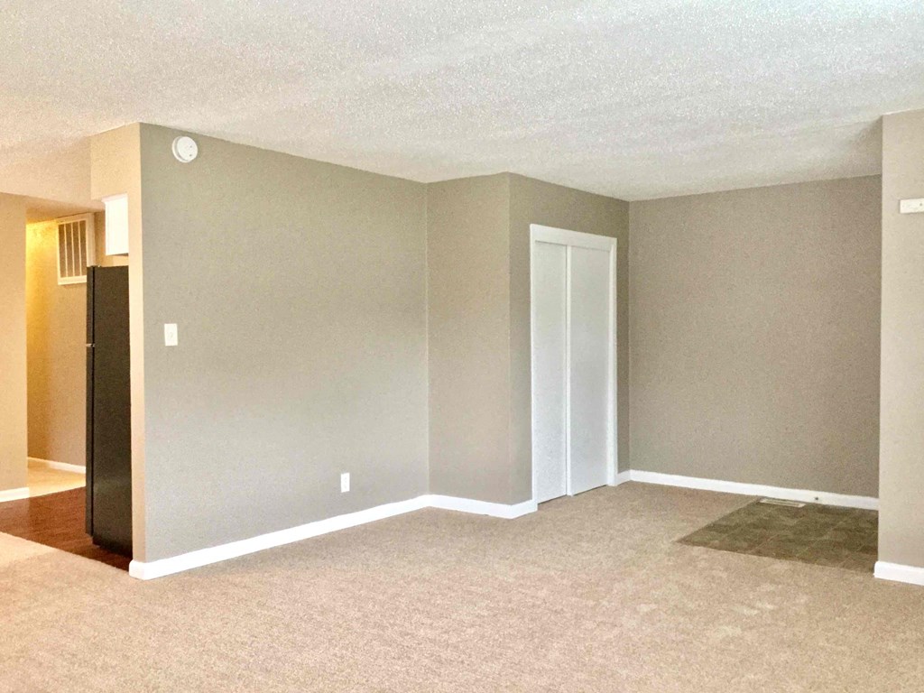 A room with a carpeted floor and a door.