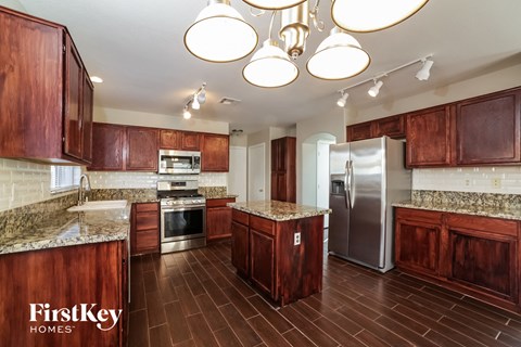 A kitchen with wooden cabinets and a granite countertop.
