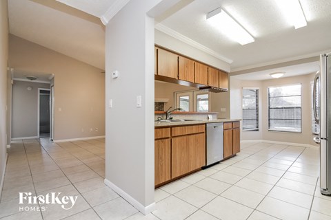 A kitchen with wooden cabinets and a refrigerator.