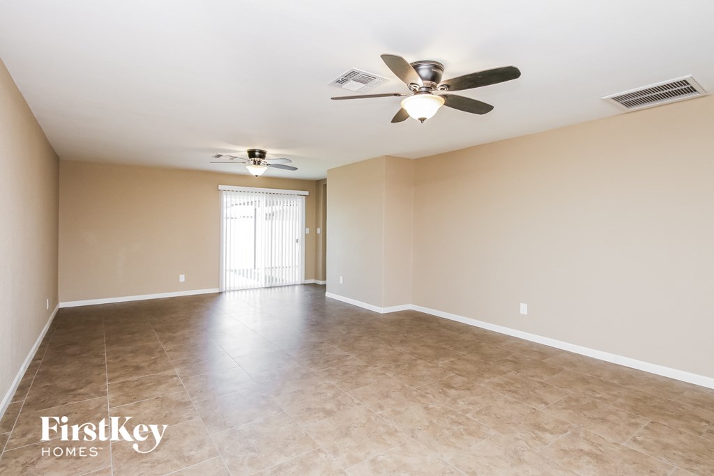 the spacious living room with ceiling fan and tile flooring