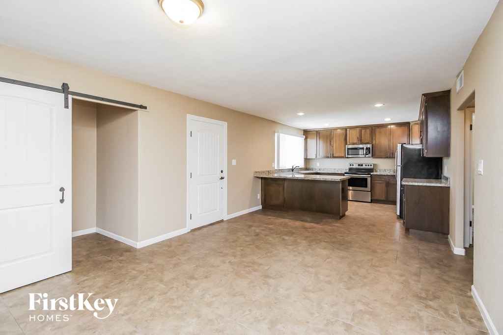 an empty kitchen with a door to the living room