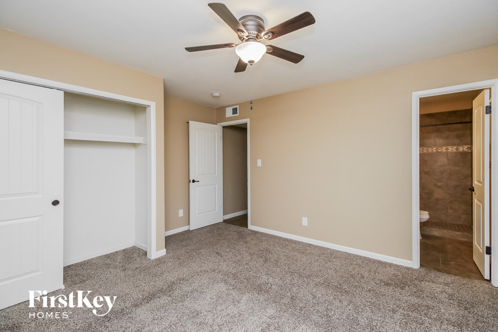a bedroom with two closets and a ceiling fan
