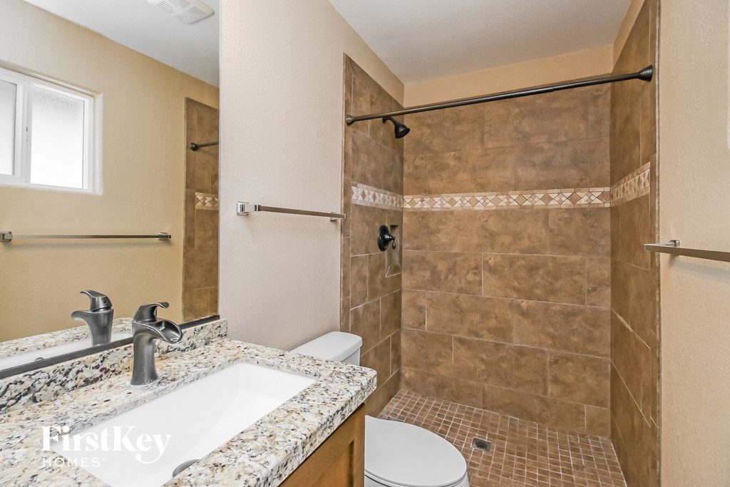 a bathroom with a shower and a sink and a toilet