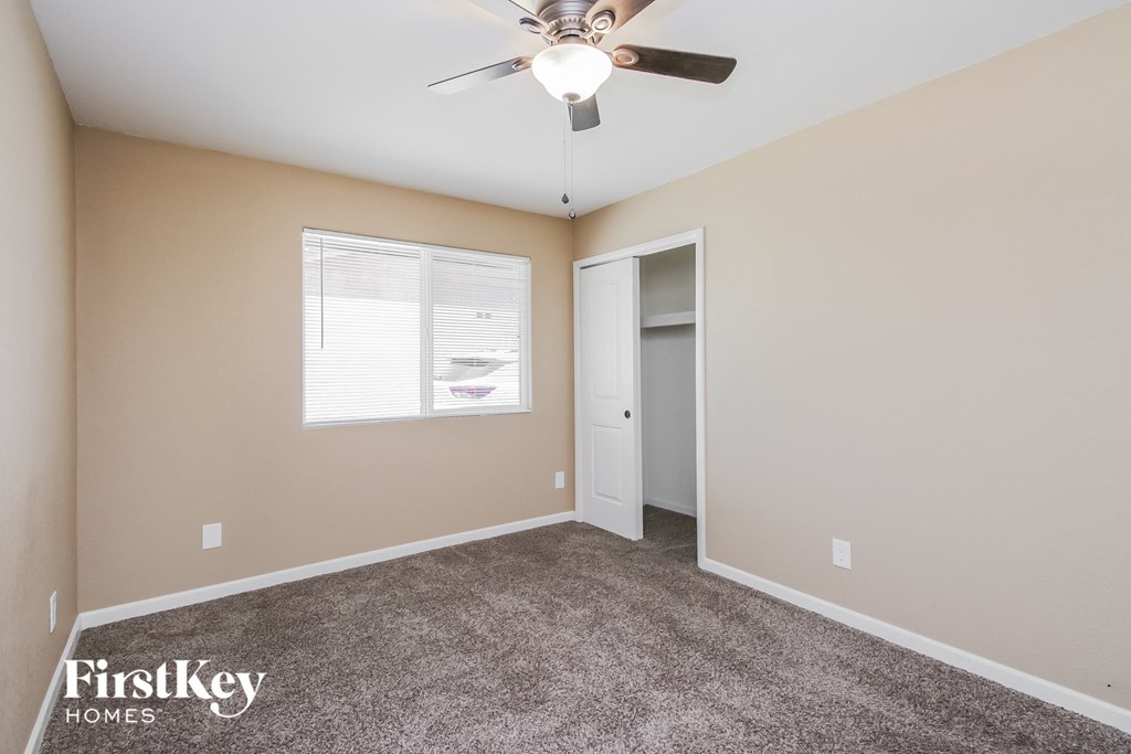 a bedroom with carpet and a ceiling fan