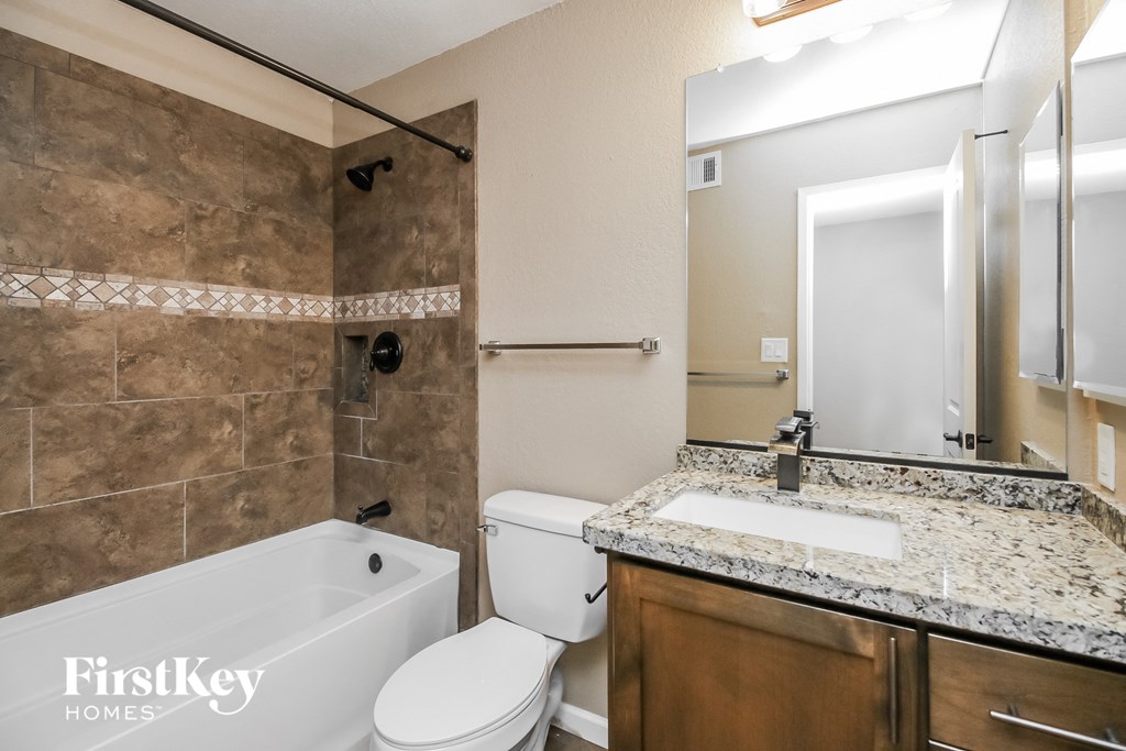 a bathroom with a toilet sink and tub and a mirror