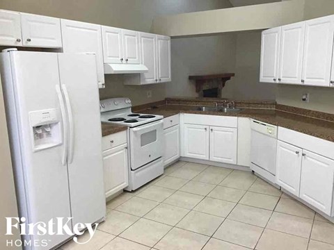 A kitchen with white appliances and cabinets.