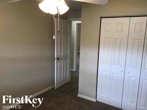 A room with a white door and a wall with a FirstKey Homes logo.