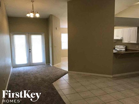 A room with a kitchen area and a dining area.