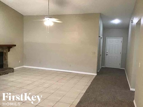 A room with a fireplace and a door in the background.