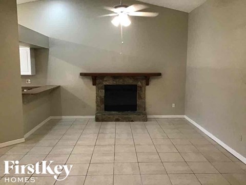 A living room with a fireplace and a ceiling fan.