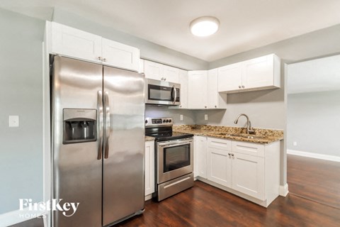 a kitchen with stainless steel appliances and white cabinets