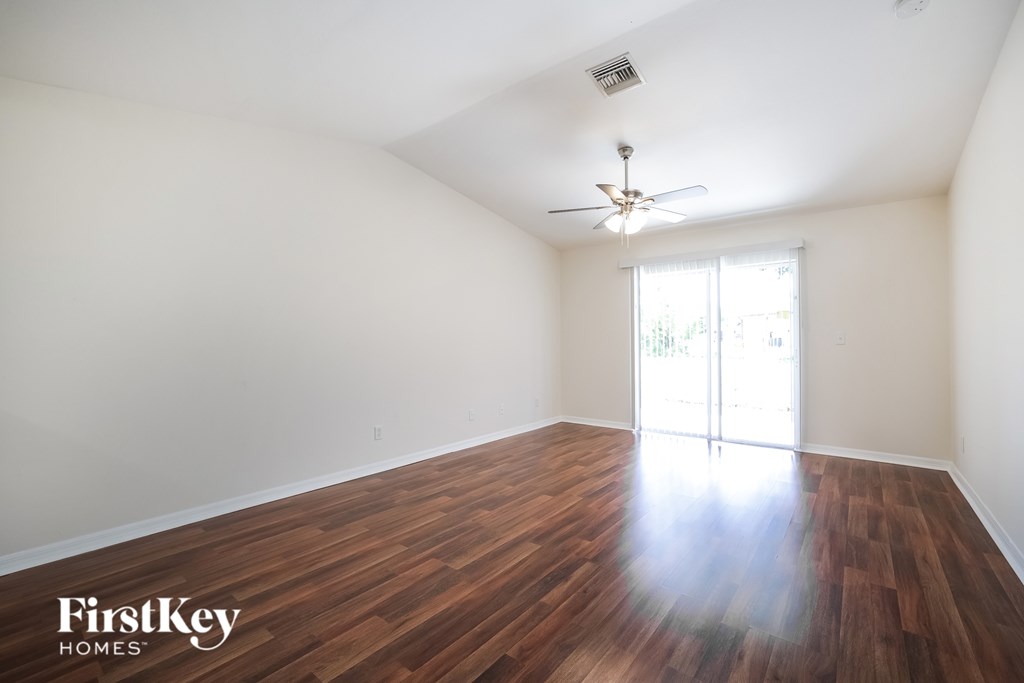 A room with wooden floors and a ceiling fan.