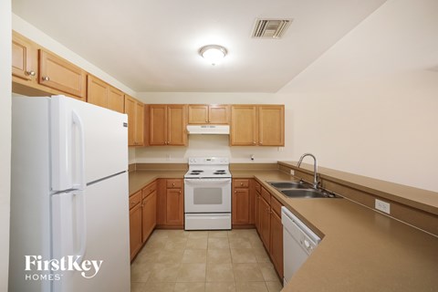 A kitchen with wooden cabinets and a white refrigerator.