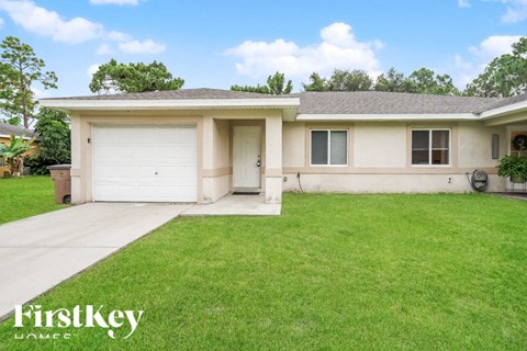 A house with a garage and a driveway in front of it.