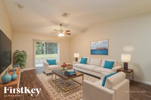 A living room with a white couch and a ceiling fan.