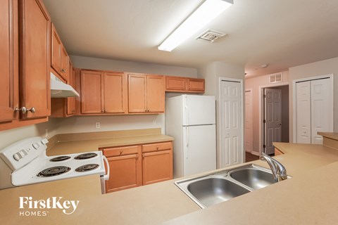 A kitchen with wooden cabinets and a stove top oven.