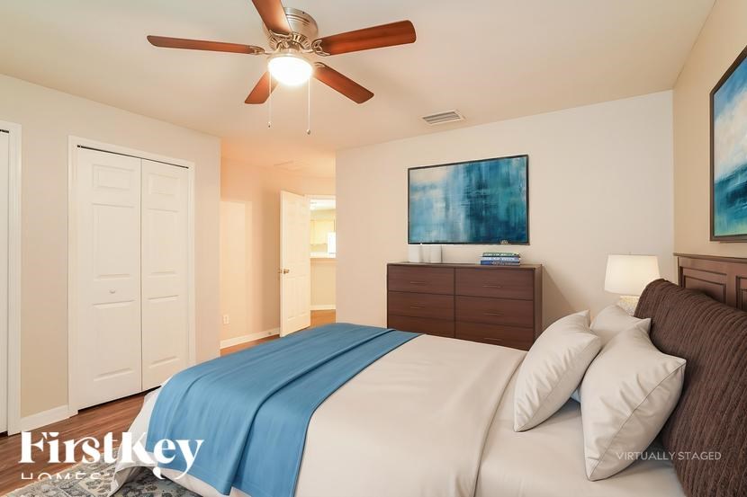 A bedroom with a bed, dresser, and painting.