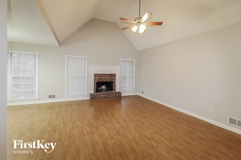 a living room with a fireplace and a ceiling fan