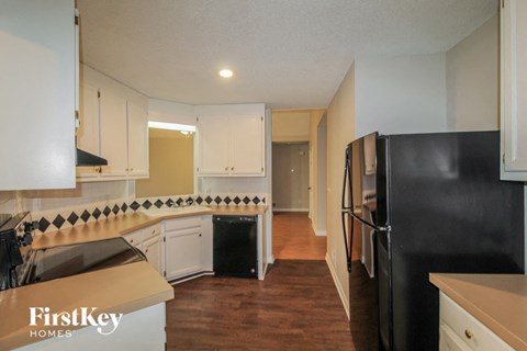 a renovated kitchen with white cabinets and black appliances