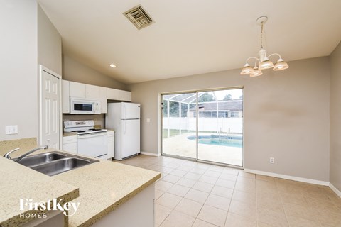 A kitchen with a sink and a refrigerator.