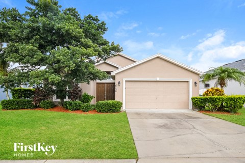 a beige house with a driveway and a garage door