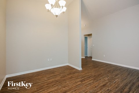 a living room and dining room with wood flooring and a chandelier