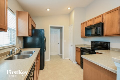 a kitchen with a sink and a black refrigerator