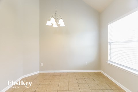 a dining room with a large window and a tiled floor